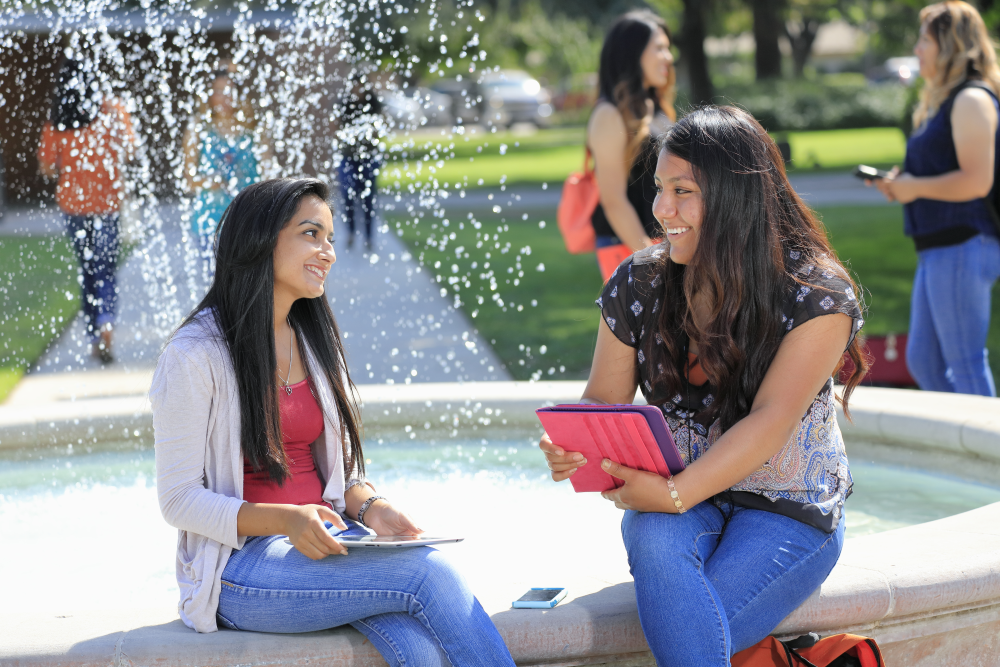 students sitting by fountain
