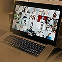 laptop with virtual meeting on screen.