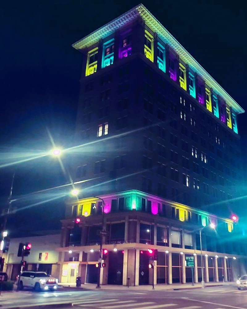 district office building at night with yellow, turquoise and purple lights