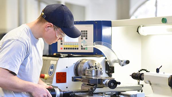 Student working with a turning machine