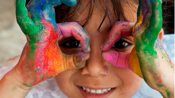 An elementary school boy playing with paint