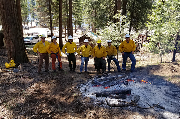 Forestry students lined up around smoldering fire.