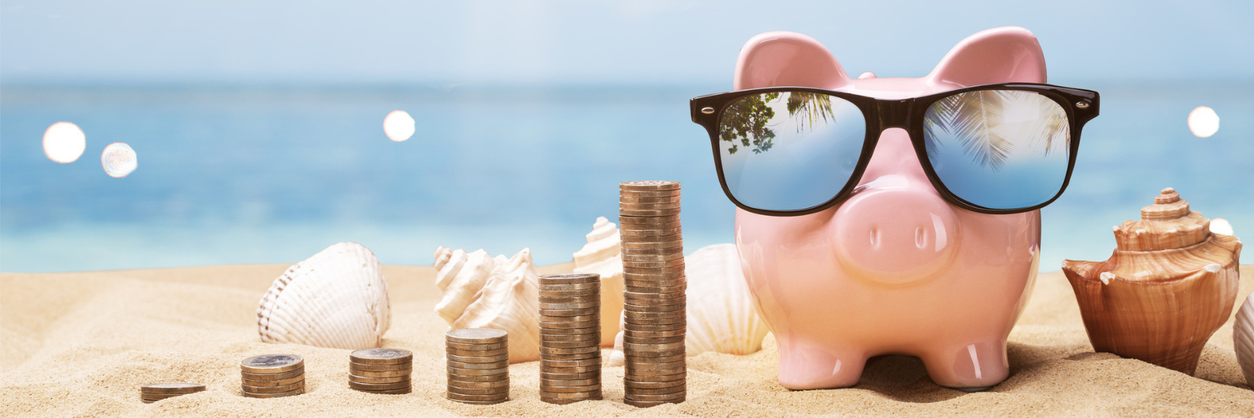 picture of piggy bank on beach with coins