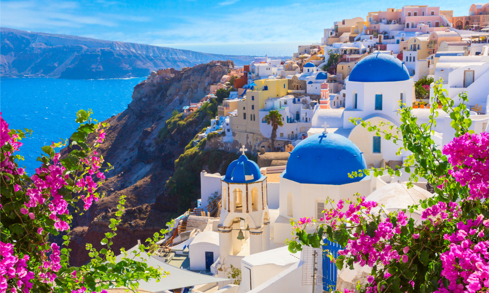 Domed buildings located on mountains with view to the ocean.