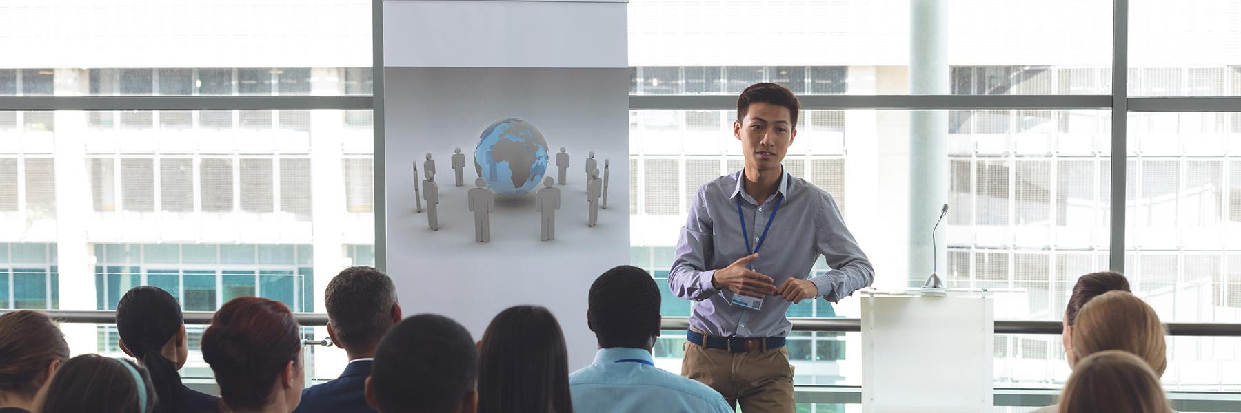 business man lecturing to a room of office workers