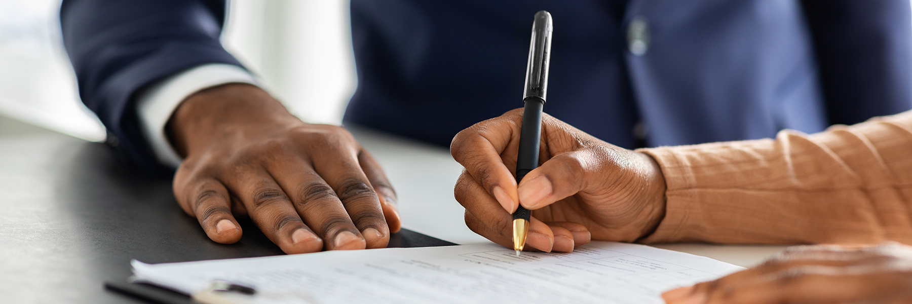 hands signing a document